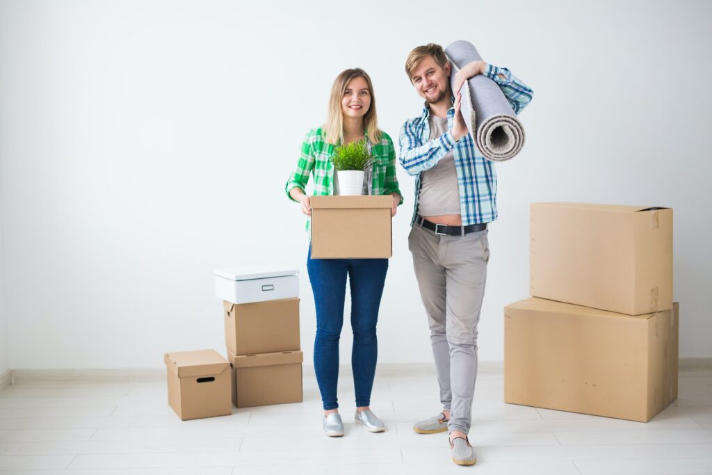 Family, new apartment and relocation concept - Young couple moving in new house