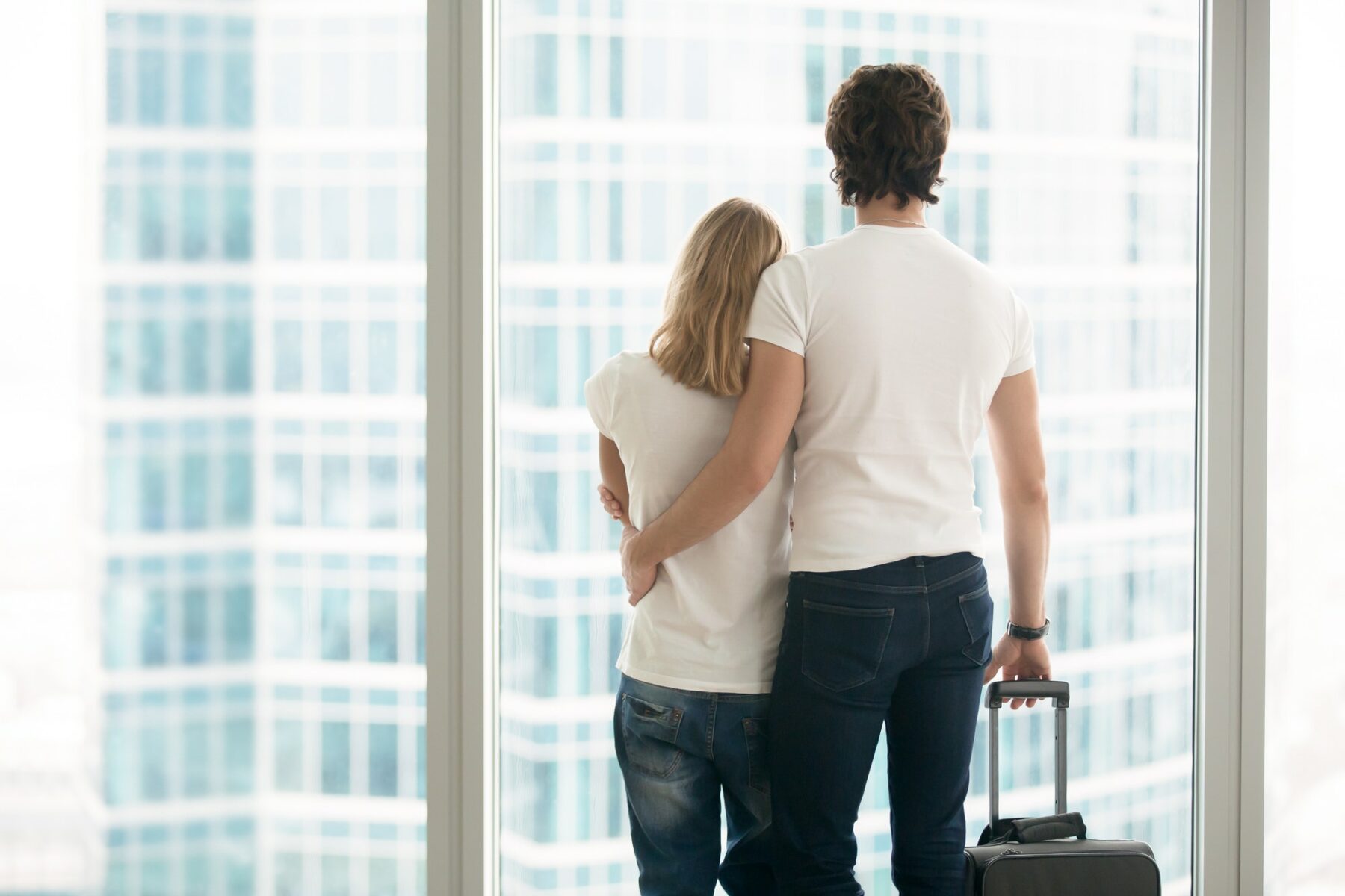 Rear view of a young couple near window